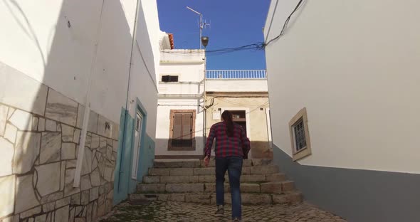 Back View of a Man Walking Up the Stairs and Then Deciding to Turn Left alt