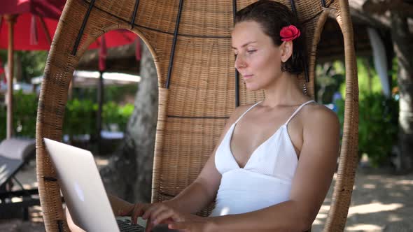 Digital Nomad Concept  White Female Working on Her Laptop From a Beach alt