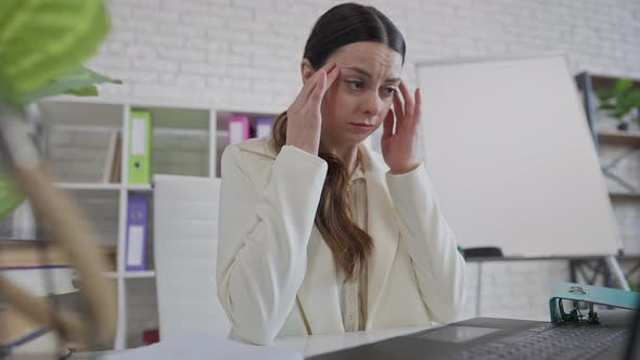 Middle Shot of Stressed Young Beautiful Woman Sitting in Office Working Online alt