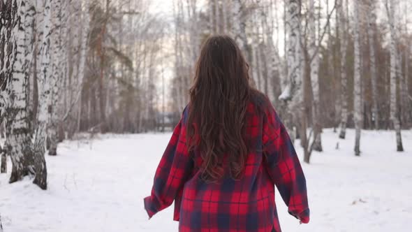 Female in Checkered Shirt Walking in Snowy Park