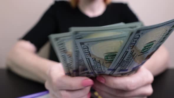 dollars in the hands of a woman, the girl counts banknotes, paper money. family budget, bill payment alt