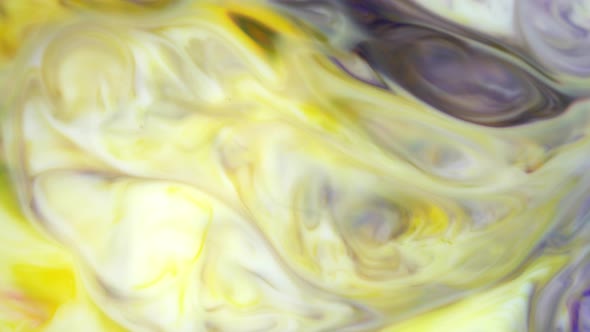 Ink in Water. Yellow and Violet Ink Reacting in Water Creating Abstract Background.