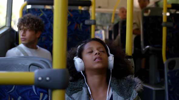 Girl listening music on headphones while travelling in bus 4k alt