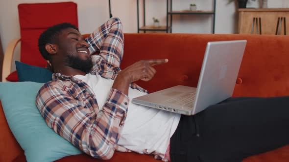 Young Man Using Laptop Computer Lying on Sofa at Home Working Online Shopping Watching Movies alt