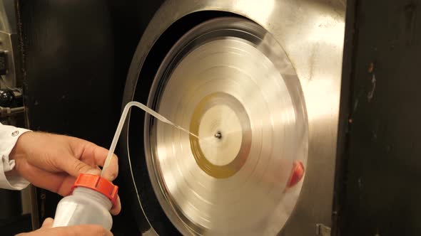 Vinyl record factory: Cleaning silver vinyl record mold with liquid alt