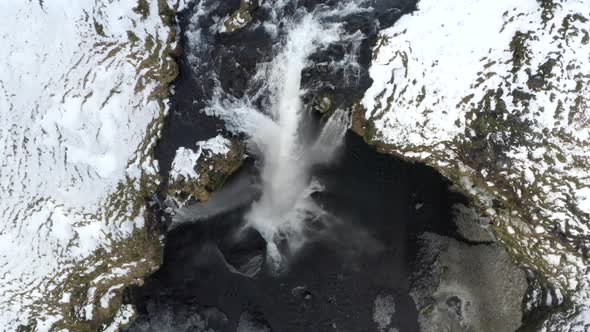 AERIAL: Close Up of Waterfall in Snow, Ice Canyon in Iceland Green Grass, Cloudy alt