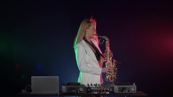 Young Sexy, Blonde Woman Dj in White Jacket Playing Music Using Saxophone on Black, Slow Motion alt