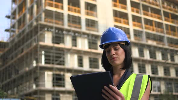 Woman looking digital tablet at construction site