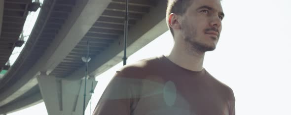 Football Player Walking with Soccer Ball in City alt