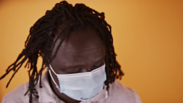 African Man with Face Mask Shaking His Braided Hair alt