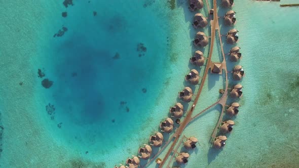 Aerial view above a group of bungalows in a luxury resort, Maldives island. alt