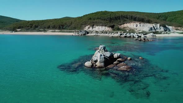 Aerial View of a Beach Turquoise Water and Huge Rocks in the Sea alt