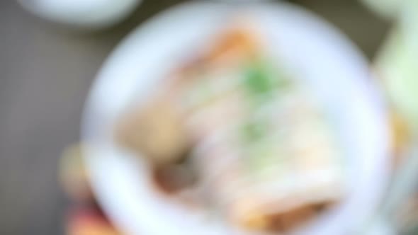Dinner plate with Chicken enchiladas garnished with green onions and sour cream. alt