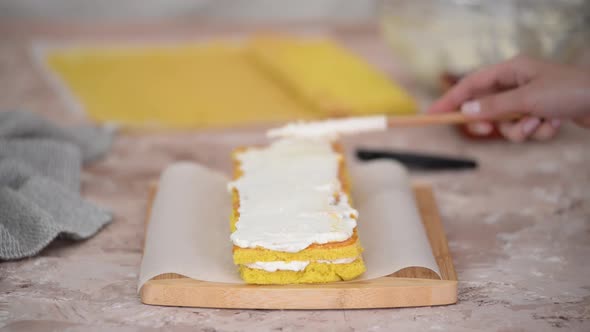 Close Up of Woman Hands Making Sweet Sponge Cake with White Cream and Apricot Jam