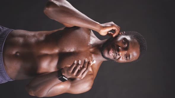 Closeup of a Darkskinned Athletic Man with a Perfect Abs on a Dark Background