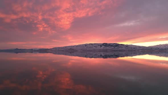View of colorful pink sunset reflecting in Utah Lake alt