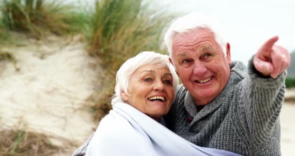 Happy senior couple pointing at view alt