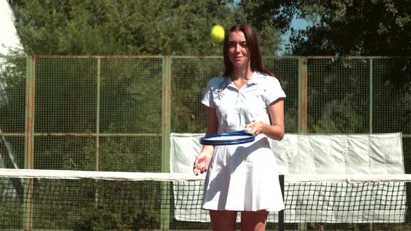 Young Sportswoman Juggling Tennis Ball on Racket