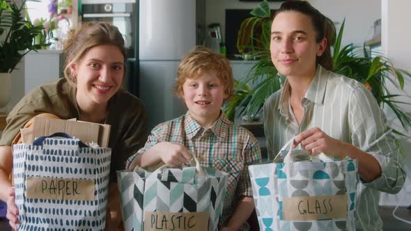 Portrait of Happy LGBT Family with Sorted Waste at Home alt