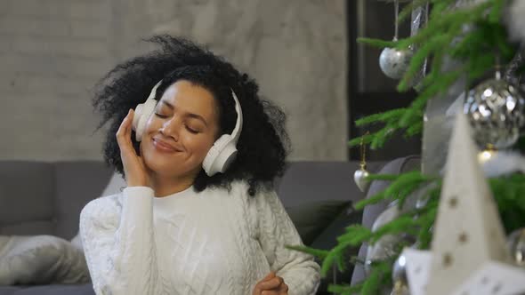 Portrait of a Happy African American Woman Listening To Music with Big White Headphones alt