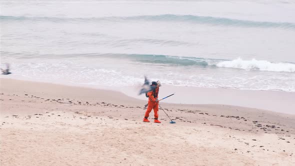 Man with a Metal Detector on the Beach