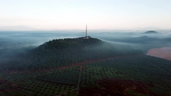 Aerial view rotational shot telecommunication tower at the top of a hill. alt