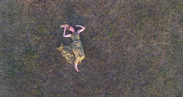 Beautiful woman lying in grass and enjoying alt