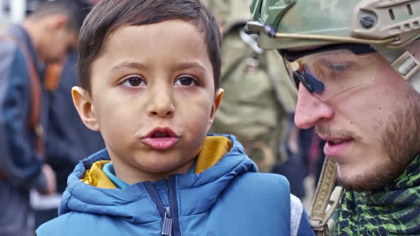 Syrian Refugee Boy Chatting with Cheerful Soldier alt