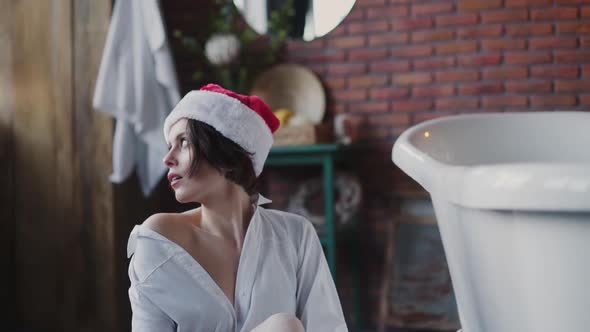 Playful Nude Lady in Red New Year Hat and Shirt Poses at Bath alt