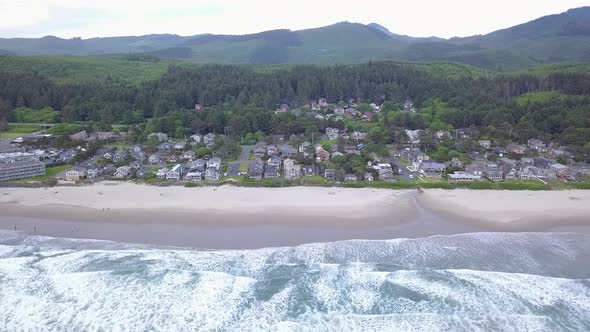 Aerial flying over Pacific Ocean revealing the town of Cannon Beach Oregon alt