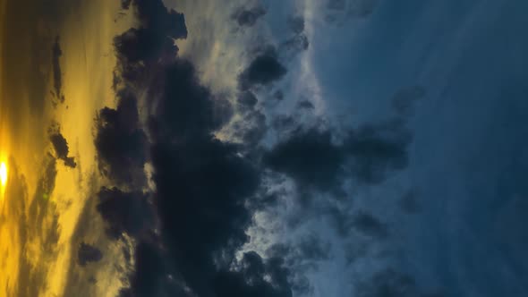 Vertical Format Video Time Lapse of Dramatic Heavy Gray Clouds at Sunset Illuminated By the Sun alt