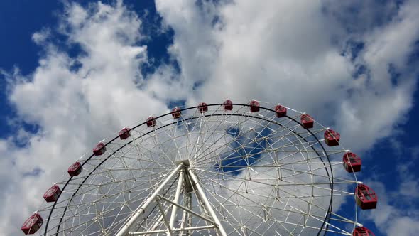 Time Lapse of Large Ferris Wheel Spinning Around on a Bright Sunny Day with Clouds Moving alt