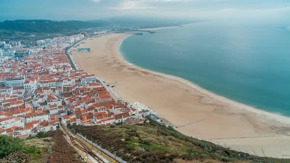 View of Nazare Panorama with Cabins of Funicular Timelapse. Fog Coming From Ocean at Evening During alt