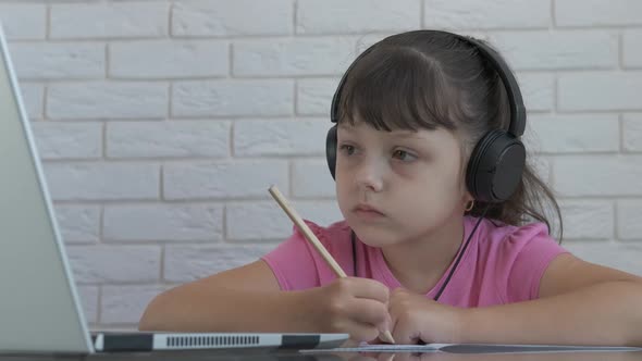 Pupil in headphones listen teacher.  alt
