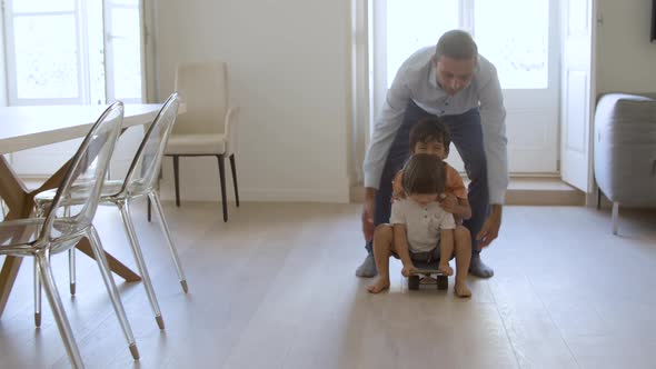 Funny Dad Playing Active Games with Little Sons at Home alt