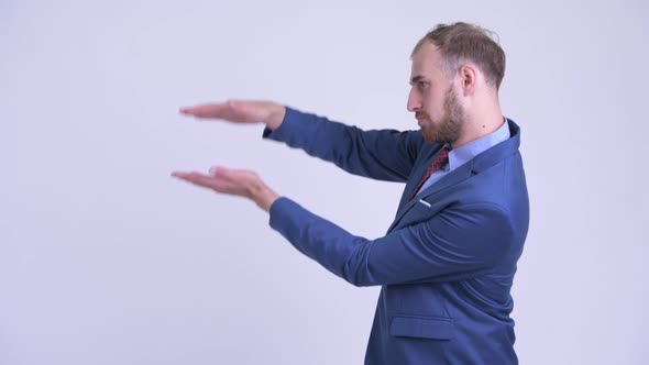 Happy Bearded Businessman Snapping Fingers and Showing Something