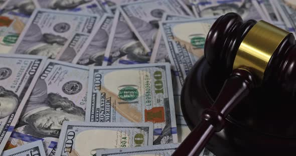 Corruption Concept with US Dollar Cash Banknote Money in Judge Gavel with the United States Flag alt