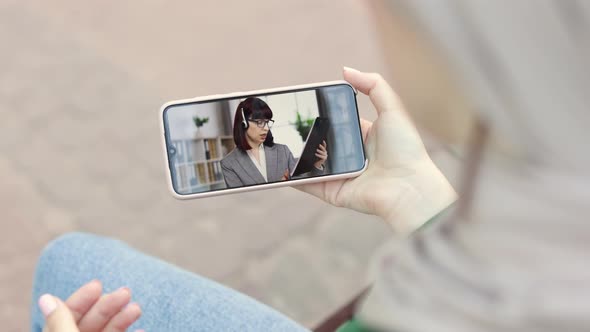 Young Muslim Woman in Park with Smartphone Talking with Her Female Office Colleague alt