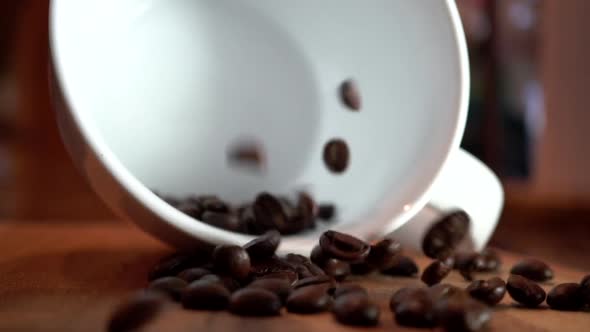 Empty Coffee Cup with Falling Coffee Beans in Slow Motion alt