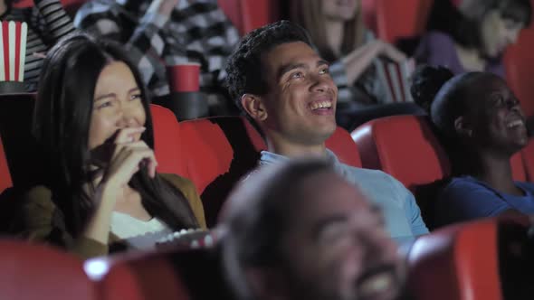 Mixed Race Couple Laughing While Watching Movie alt