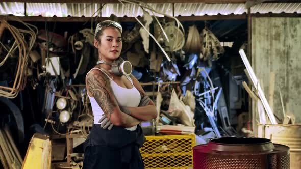 Attractive young woman mechanical worker repairing a vintage car in old garage. alt
