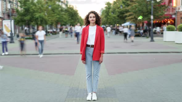 Time Lapse Portrait of Goodlooking Woman Standing in Pedestrian Street Alone Among Crowd of People alt