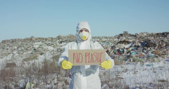 Portrait of Man Wore in Protective Suit Show Protest Sign "No Plastic" at Camera alt