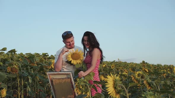 Pretty Female Artist Painting Her Man Presents a Sunflower and They Have a Fun alt