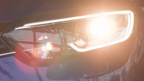 Details of Switched on Front Lights of Anonymous Prestigious Luxury Modern Car alt