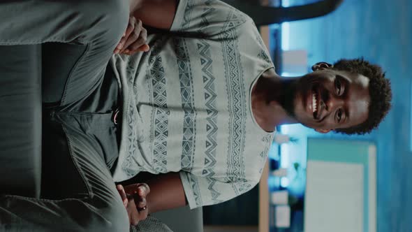 Vertical Video POV of Person Smiling and Sitting on Couch alt