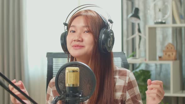 Over Shoulder View, Young Asian Woman In Headphones Singing While Recording Podcast With Male alt
