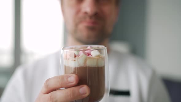 Man Drinking Cocoa with Marshmallows alt