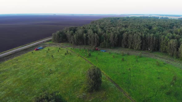 Red agricultural machinery works in the field alt