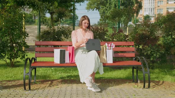 Happy Female Typing on Laptop Outdoors